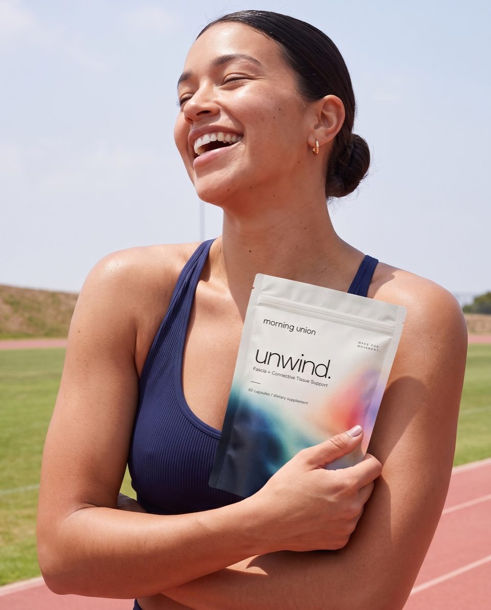 Woman laughing on a running track, holding unwind.