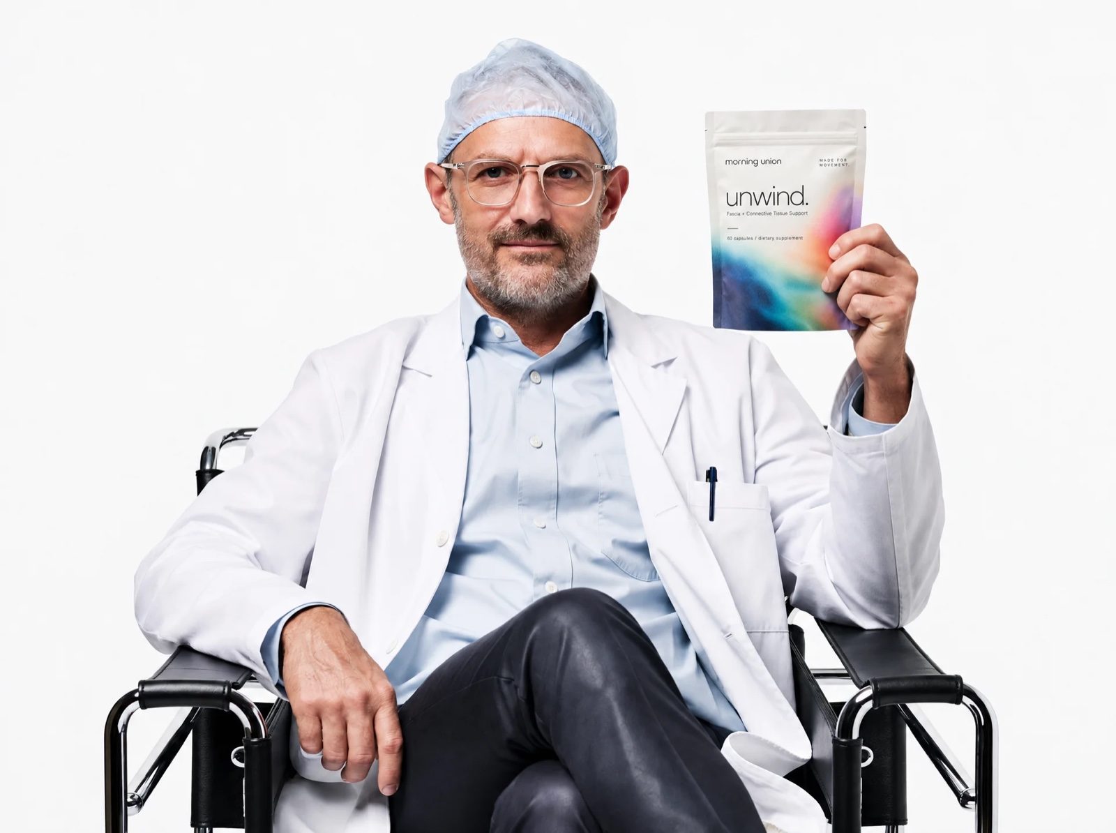 Man in a white coat holding a pouch of unwind.